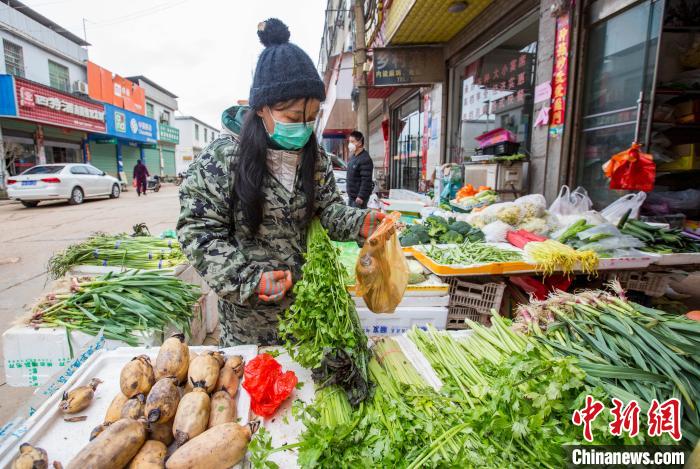 2月7日，在江西省九江市都昌县周溪镇一家超市，工作人员为村民代购物品。　傅建斌 摄