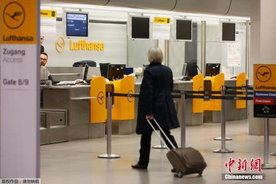 资料图：德国柏林，一名旅客从汉莎航空值机柜台前走过。
